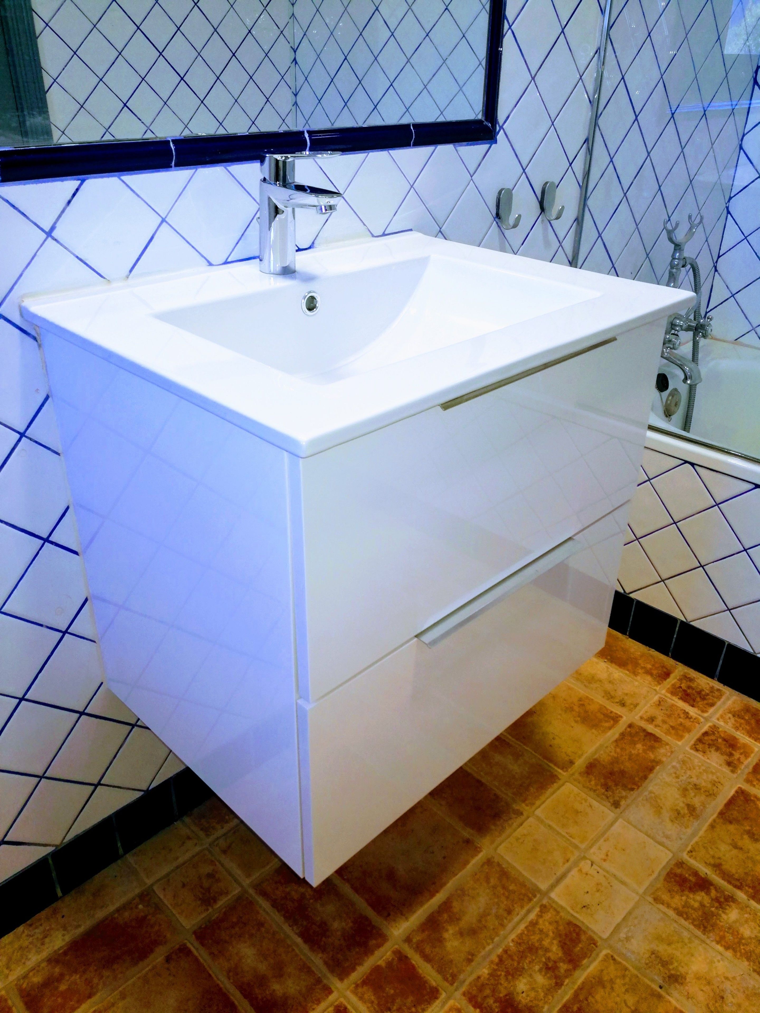 A bathroom with a white sink, a mirror, and a shower.