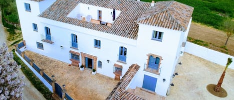 A large white building with multiple windows and a tiled roof.