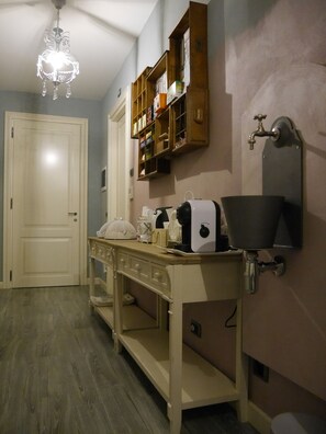 A bathroom with a wooden vanity, a sink, a mirror, a towel rack, and a shelf with toiletries. - B&B L'Ortodellerose (Alba)