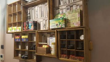 A wall-mounted shelf with various coffee and tea products, including boxes and tins.