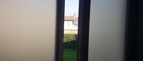 A view through a door opening to a courtyard with a building in the background.