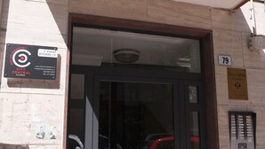 A building entrance with a sign for City Central in Bologna, a 4th piano, and a number 79 sign. - City Central (Salerno)