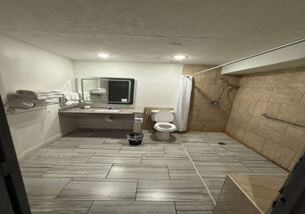 Et badeværelse med brusebad, toilet og vask.