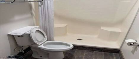 Une salle de bain équipée de toilettes, d’une douche et d’un porte-serviettes.