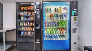 Two vending machines, one labeled 'PUSH' and the other 'AQUAFINA', with various snacks and beverages inside.