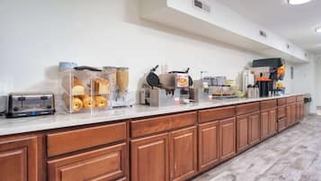 A breakfast bar with a toaster, waffle maker, and coffee machine.