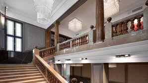 Una majestuosa escalera con barandilla de madera y suelo de cuadros.