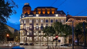 Un edificio histórico con arquitectura clásica, amplias ventanas y una cúpula destacada.