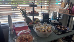 A breakfast table with various food items, including donuts, fruits, and pastries. - Buddy's Harbor (Lake Ozark)