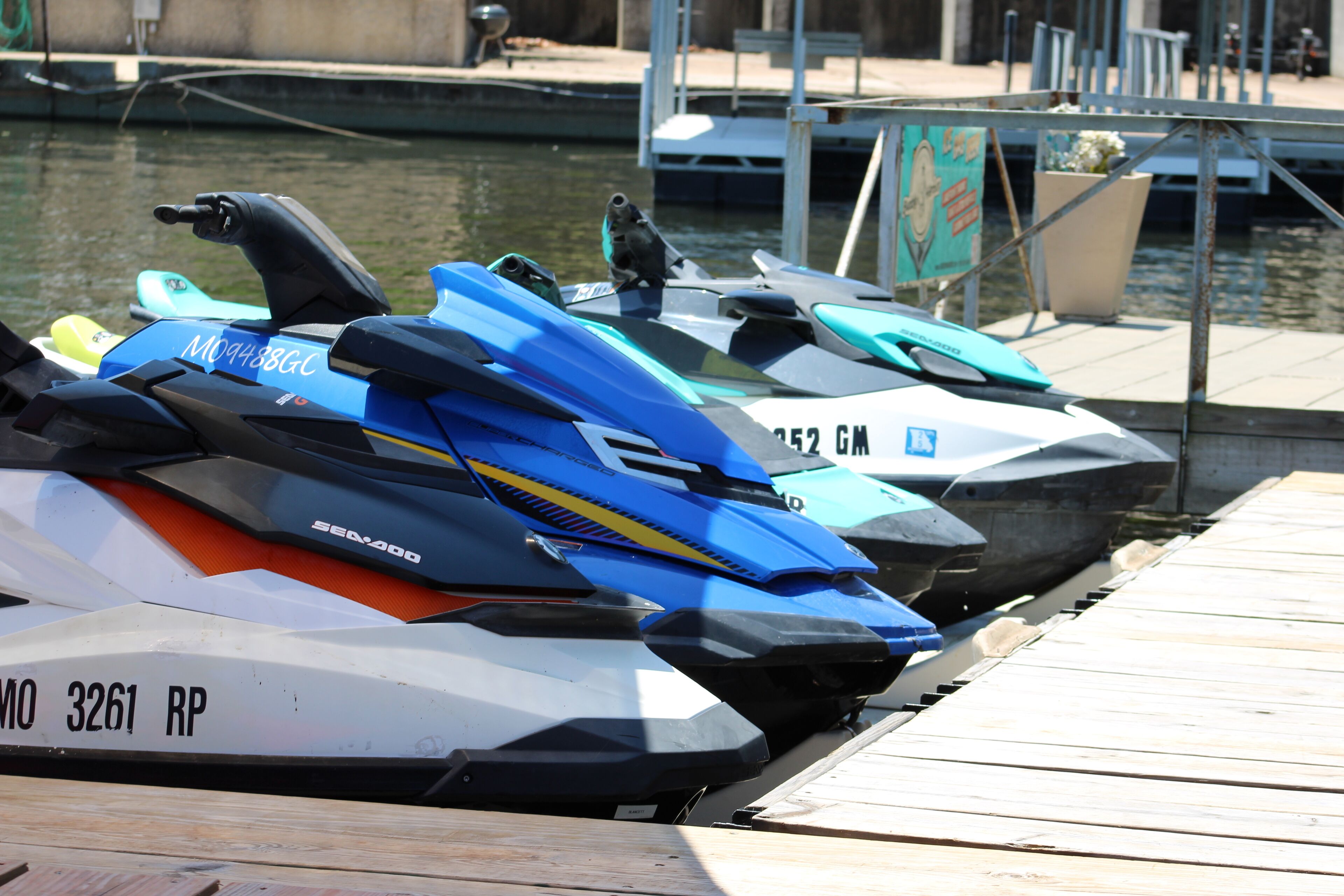 Jet skis docked at a marina with a wooden dock.