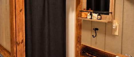 A bathroom with a shower curtain, a sink, and a mirror.