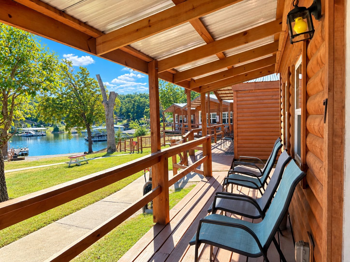 Une terrasse en bois avec des sièges extérieurs et une vue sur un lac.
