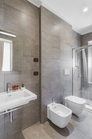 Kolmen hengen deluxe-huone, kylpyhuone makuuhuoneen yhteydessä, kaupunkinäköala | Kylpyhuone | Suihku, ilmaiset hygieniatuotteet, hiustenkuivaaja, kylpytakit