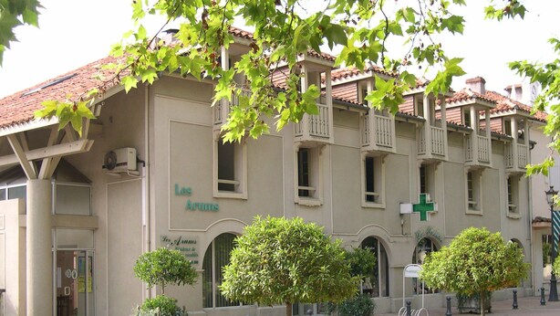 Un bâtiment sur lequel on peut lire l’inscription « Les Arums ».