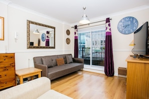 Relax in this stylish living room with a comfortable sofa, wooden side table, and large mirror.