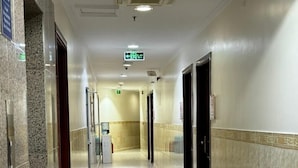 A hotel corridor with marble flooring, doors, and a trash bin. - Sidra Alia AL-DAHABI hotel - فندق السدرة العالية الذهبي (Madinah)