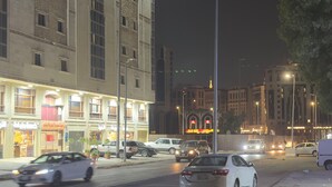 A nighttime street view with a large building featuring multiple floors and large windows. - Sidra Alia AL-DAHABI hotel - فندق السدرة العالية الذهبي (Madinah)