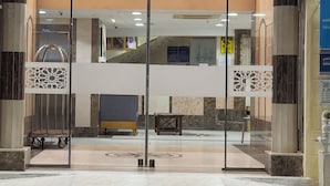 The entrance of Sidra Alia Aldahabi Hotel with a glass door and a reception desk inside. - Sidra Alia AL-DAHABI hotel - فندق السدرة العالية الذهبي (Madinah)