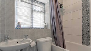 Un bagno con lavandino, WC e vasca da bagno.