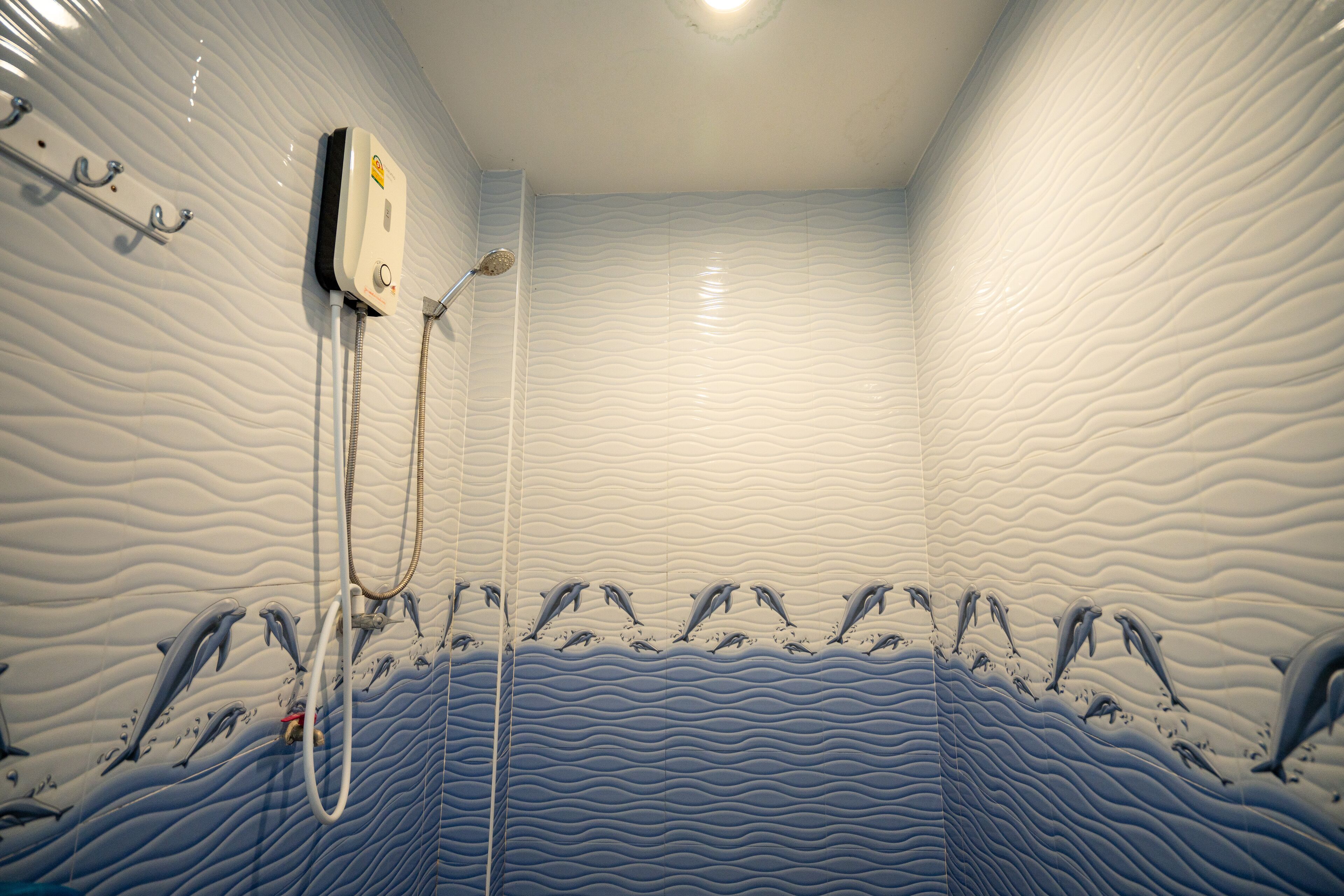 A bathroom with a wavy wall design and a shower area with a dolphin mural.