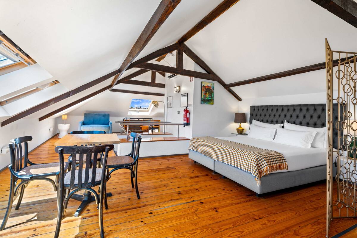 A bedroom with a bed, a desk, and a chair.