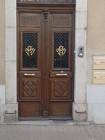 Puerta doble de madera con paneles de vidrio decorativos y un teclado electrónico.