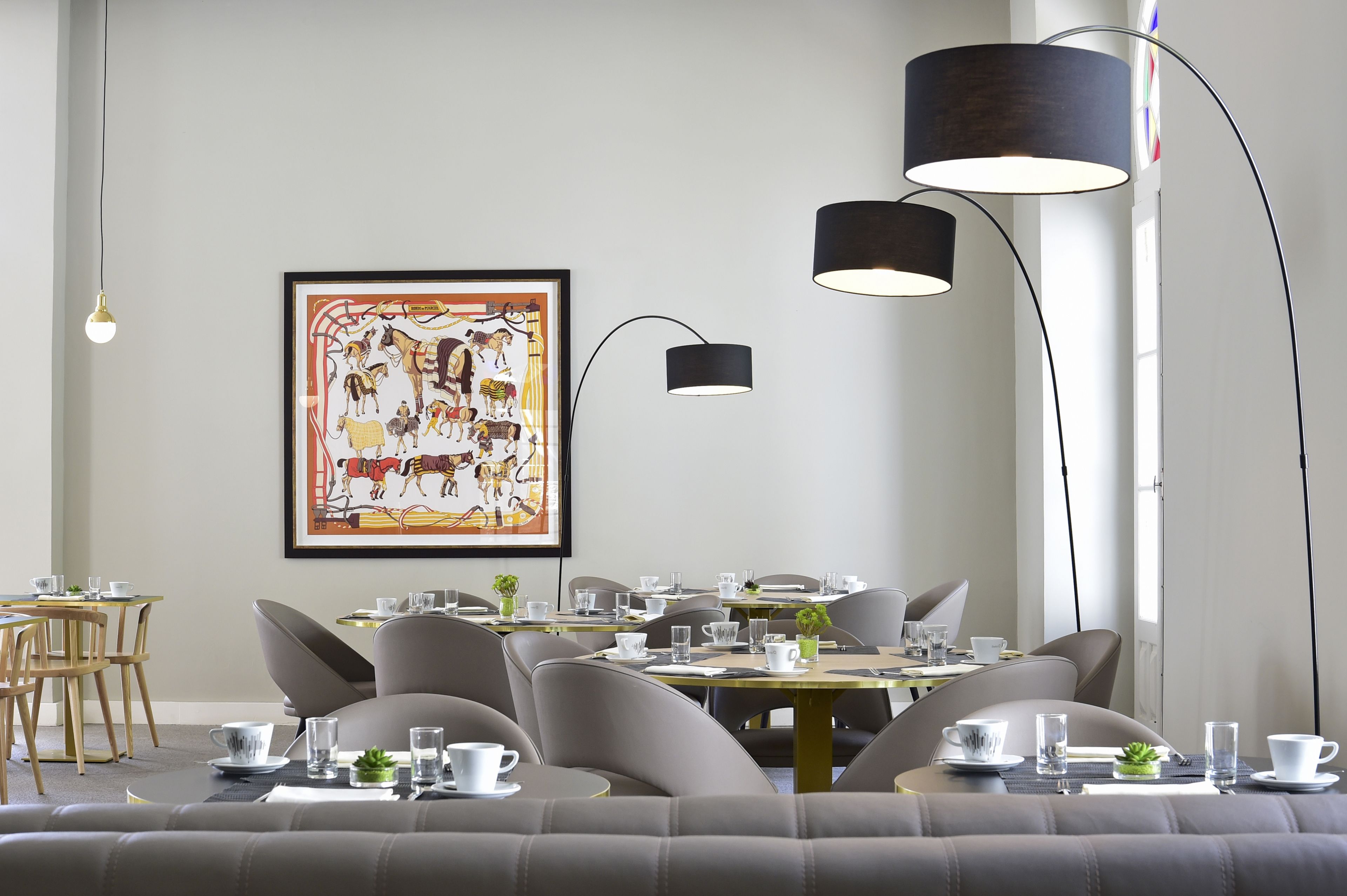 A dining area with a large framed artwork, modern chairs, and a table set for a meal.