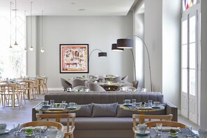 A modern dining area with round tables, cushioned seating, and pendant lighting. - Central Monchique Hotel by Unlock Hotels (Monchique)