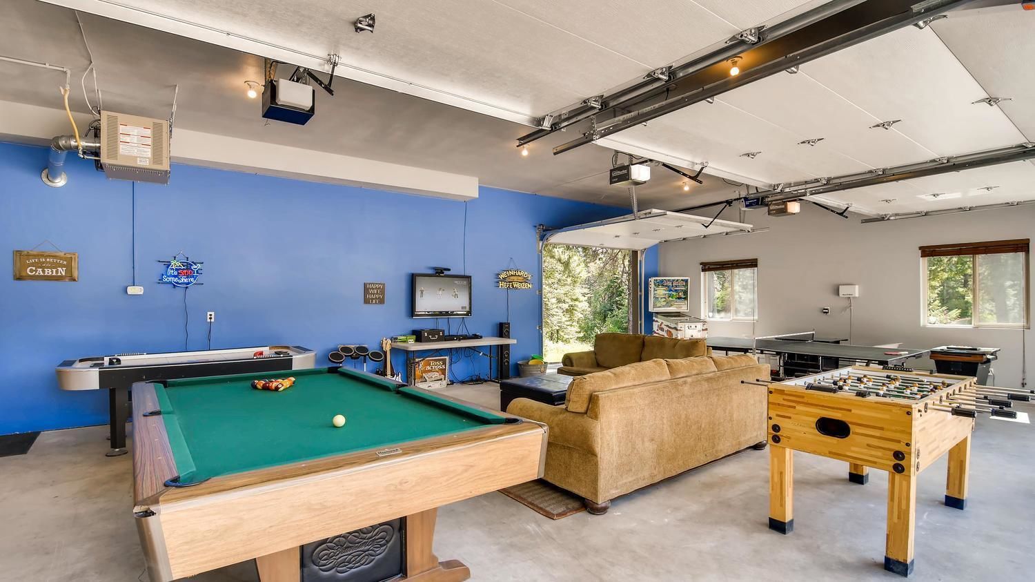 Une pièce équipée d’une table de billard, d’un baby-foot, d’un canapé et d’un téléviseur.