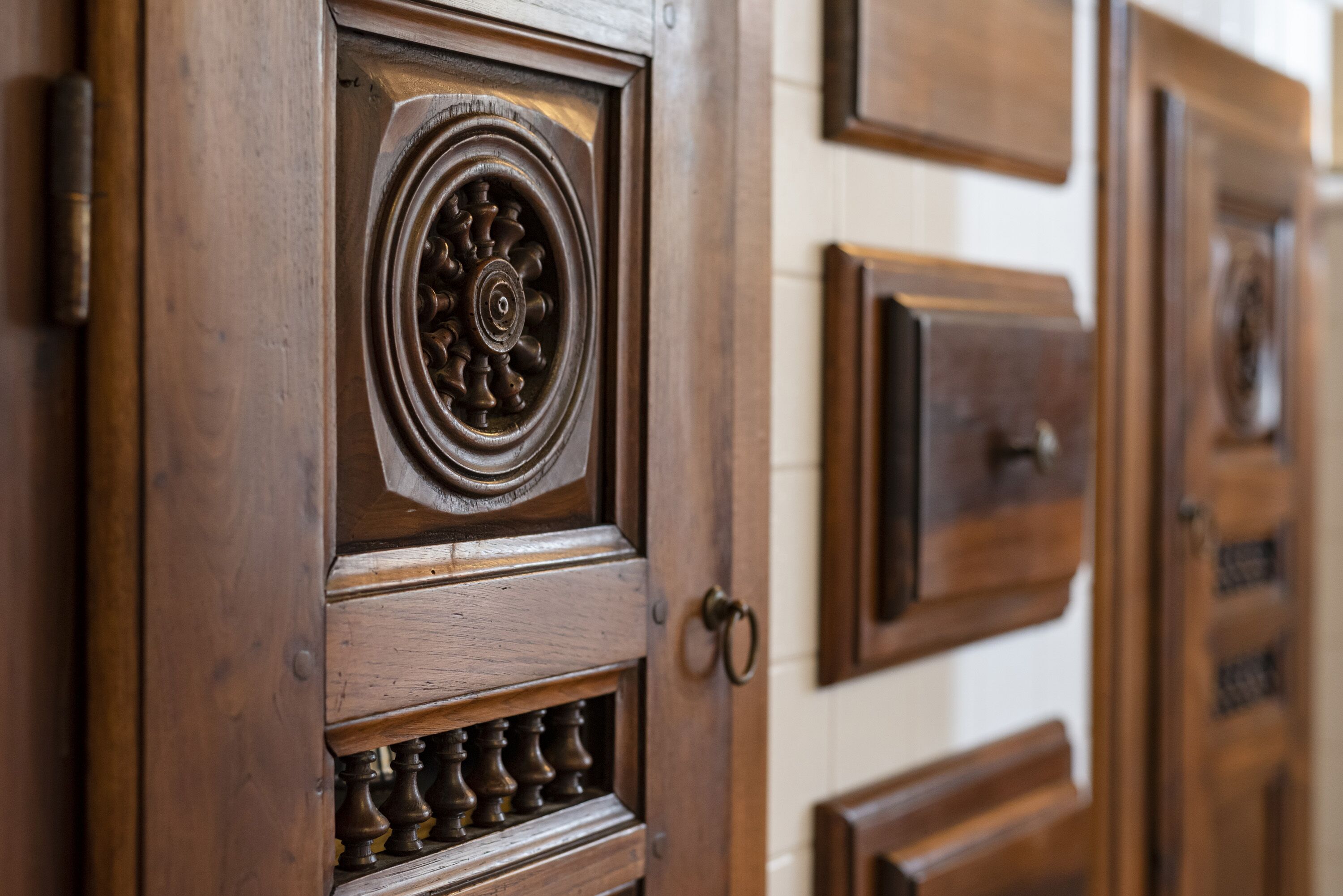 Uma porta de madeira com esculturas detalhadas e um desenho em medalhão circular.