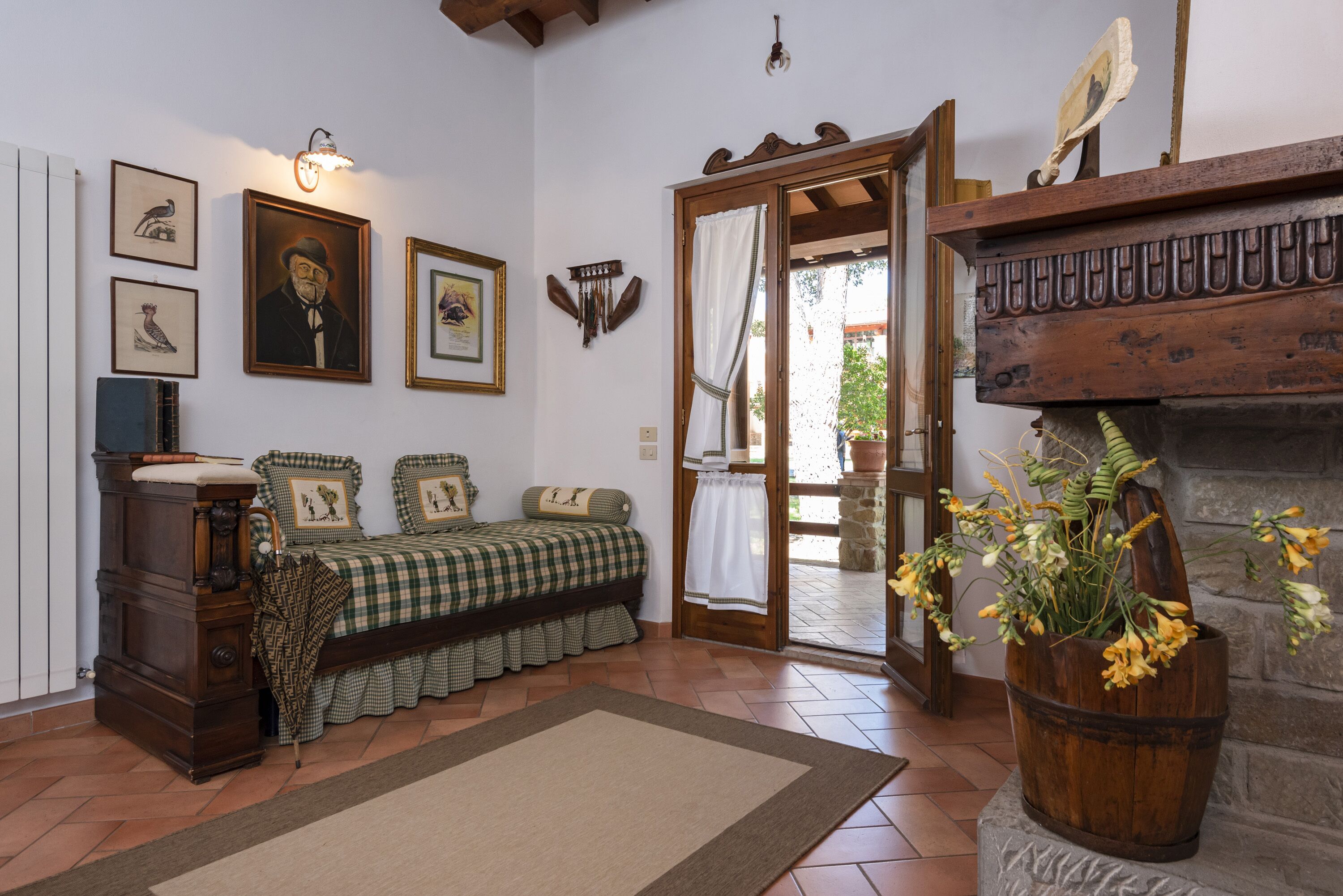 Una habitación acogedora con una cama de cuadros, un armario de madera y una chimenea de piedra.