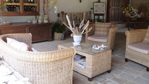 A rustic interior with wicker furniture, stone flooring, and wooden beams. - Agriturismo La Rombaia (Castiglione della Pescaia)