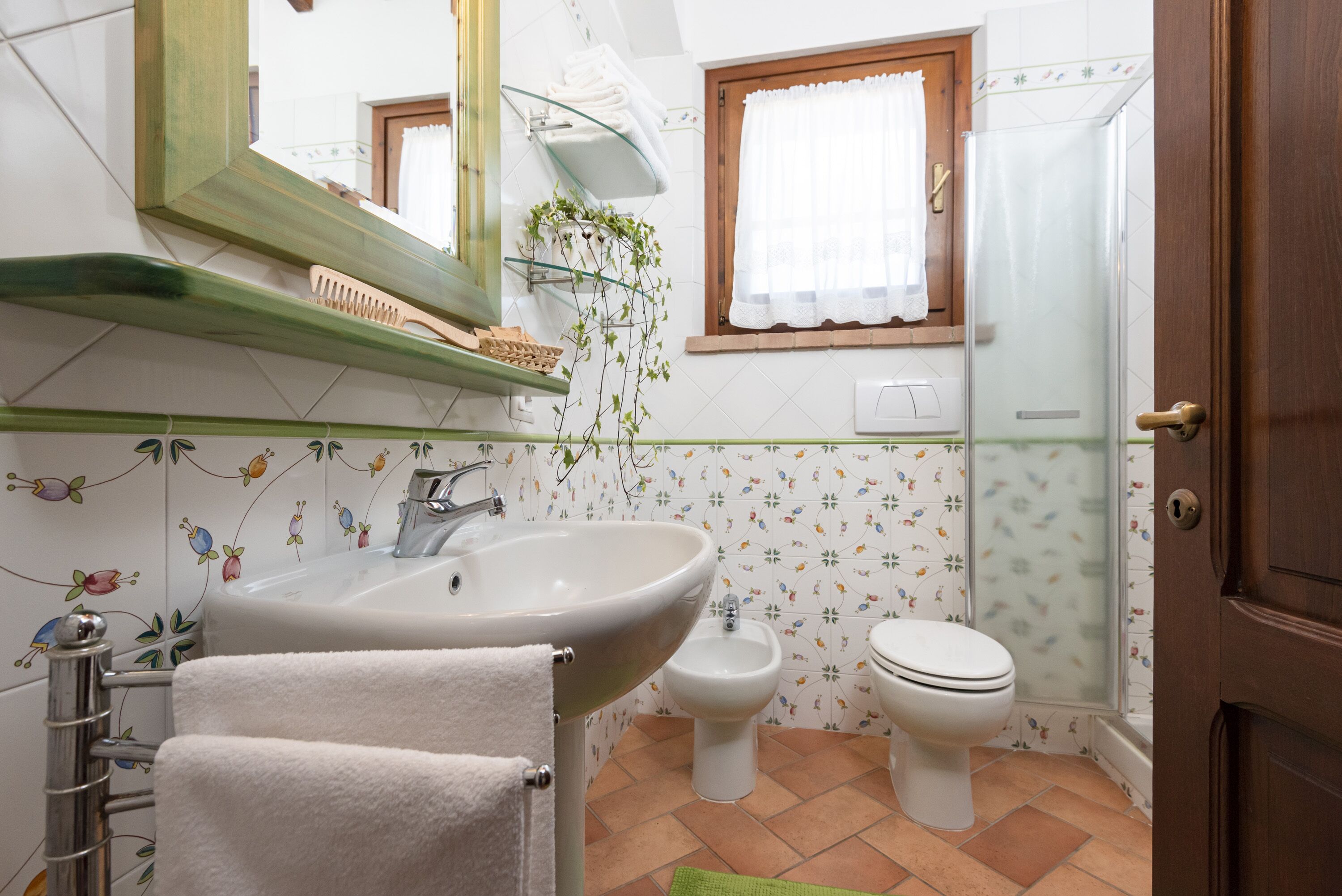 Un baño con lavamanos, bidé, inodoro y zona de ducha.