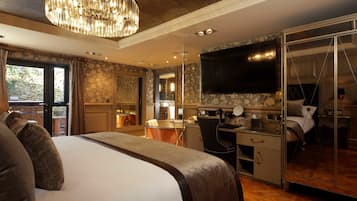 A hotel room with a large bed, a desk, a television, and a bathroom.