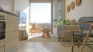 Una sala de estar moderna con un ventanal grande, un sofá, una mesa de centro y un comedor.