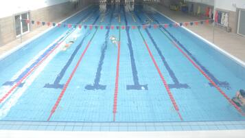 Une piscine avec des couloirs délimités et un sol carrelé.