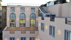 Un edificio de varios pisos con balcones, ventanas grandes y una escalera.