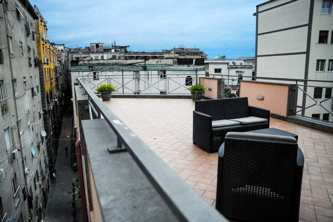 Une terrasse sur le toit, avec des sièges en plein air et une vue sur le paysage urbain.