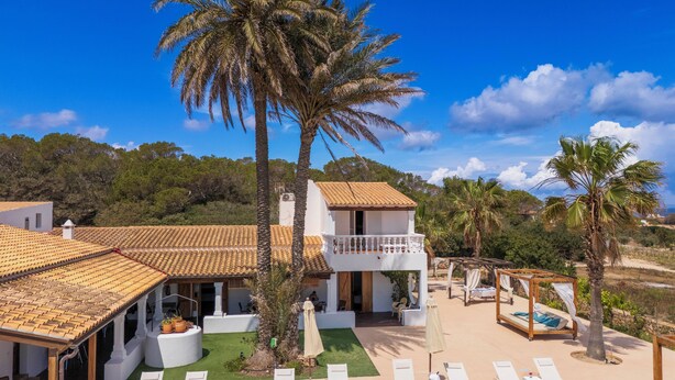 A villa with a tiled roof, a balcony, and a pool area with sun loungers. - Es Pas Formentera Agroturismo (Formentera)