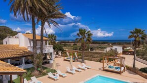 A resort with a swimming pool, lounge chairs, and a view of the sea. - Es Pas Formentera Agroturismo (Formentera)