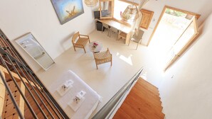 A room with a desk, two chairs, a large mirror, a painting, and a window. - Es Pas Formentera Agroturismo (Formentera)