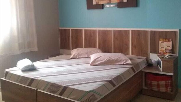 A bedroom with a bed, a ceiling fan, a nightstand, and a wall-mounted picture. - Hotel Flex In (Osasco)