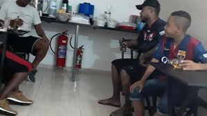 A group of people seated at a table in a room with a tiled floor and a fire extinguisher mounted on the wall. - Hotel Flex In (Osasco)