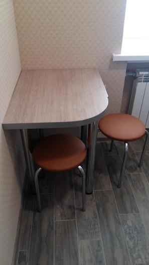 A corner dining area with a wooden table and two brown chairs. - Hostel Voyage (Kyiv)