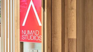 Una puerta de madera con un letrero rojo que dice "NUMAD STUDIOS".