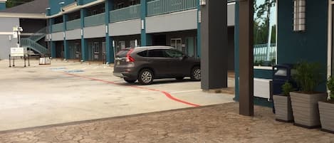 A multi-story building with a parking area in front.