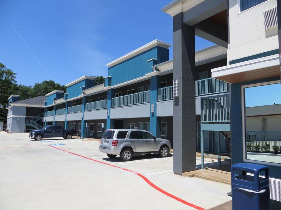 A multi-story parking garage with a blue and white color scheme, featuring a ramp for accessibility.