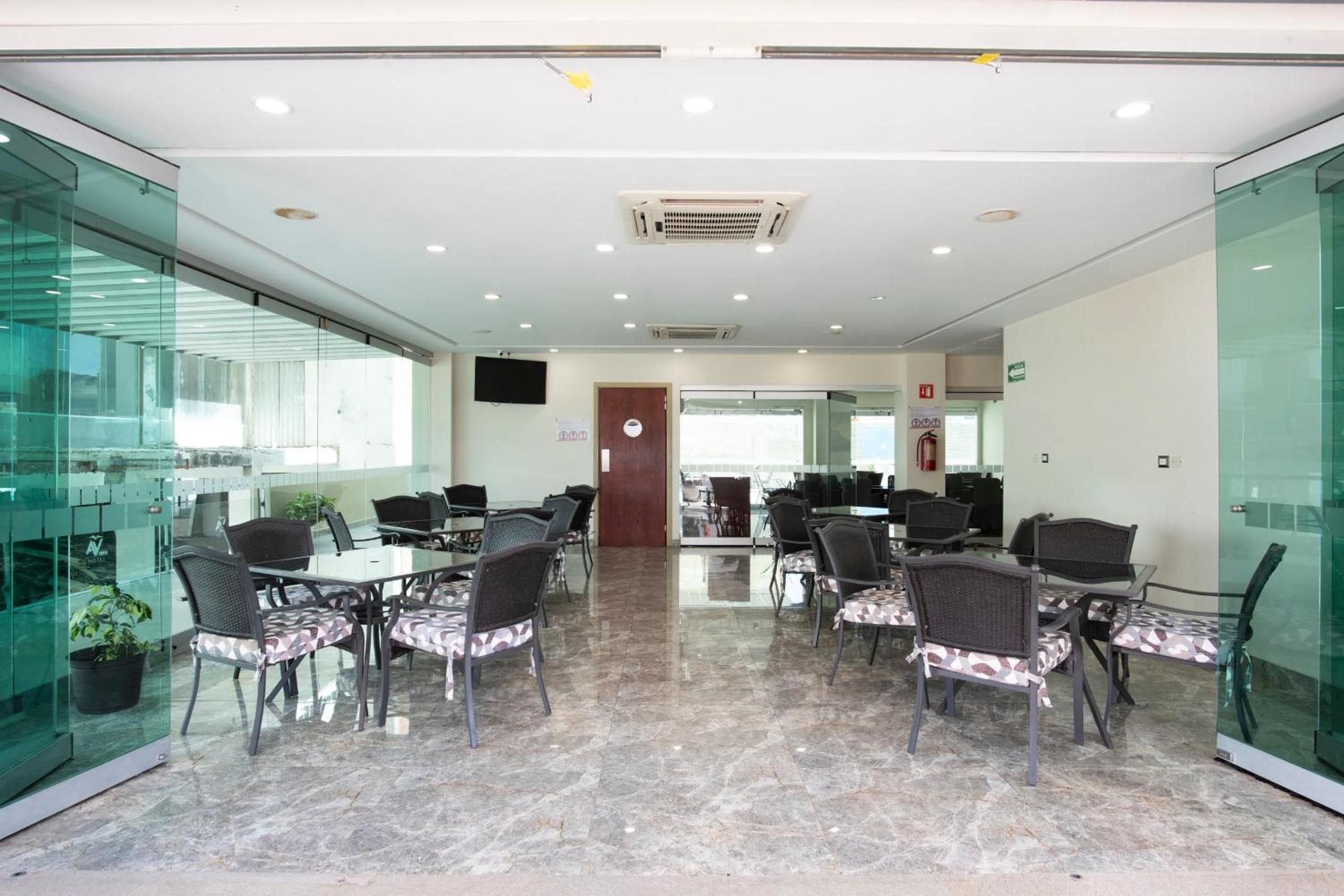 A conference room with glass walls, a marble floor, and a door leading to another room.