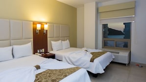 A hotel room with two beds, a large window with a view, a bedside table with a lamp, and a wall-mounted air conditioning unit. - Hotel Ave Inn Mazatlán (Mazatlán)