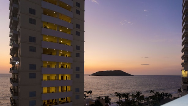 A high-rise hotel with multiple balconies overlooking a beach and ocean. - Hotel Ave Inn Mazatlán (Mazatlán)